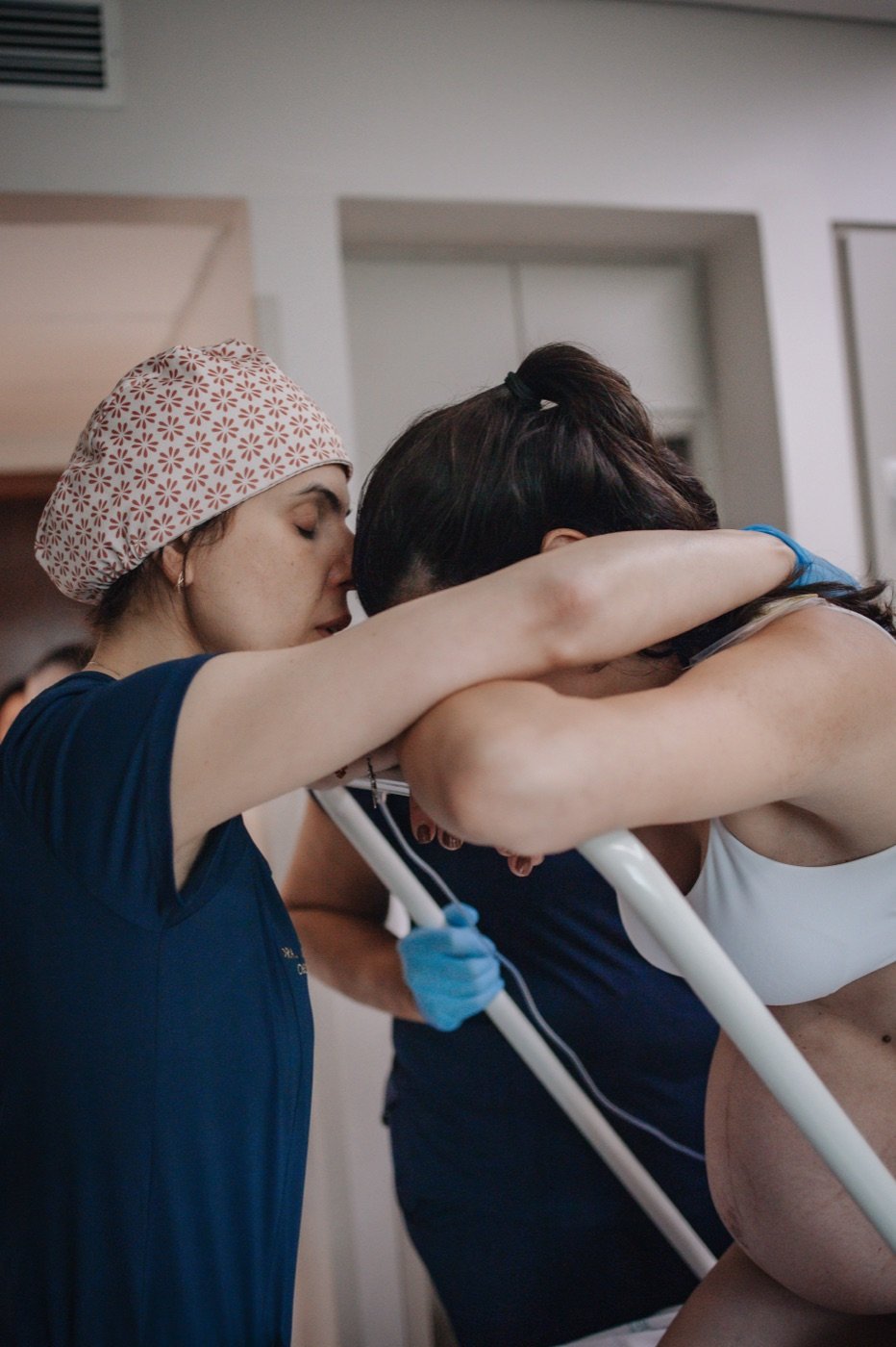 Dra. Marina Mariz beijando a cabeça de uma mulher em trabalho de parto durante o acolhimento.